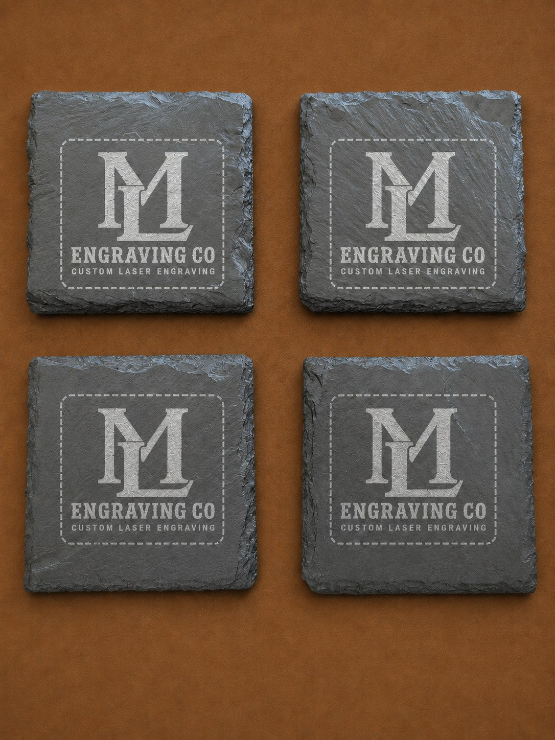 Set of four natural slate coasters laser engraved with the ML Engraving Co logo