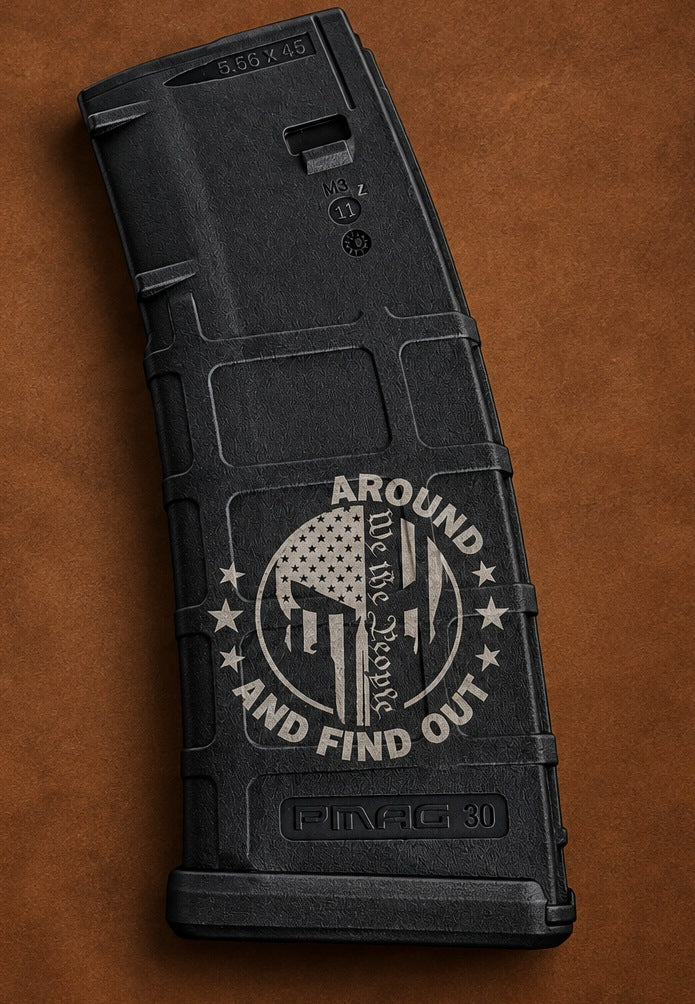 Black Magpul PMAG 30 magazine laser engraved with a flag-filled skull, We the People, and Around and Find Out with the first word left blank
